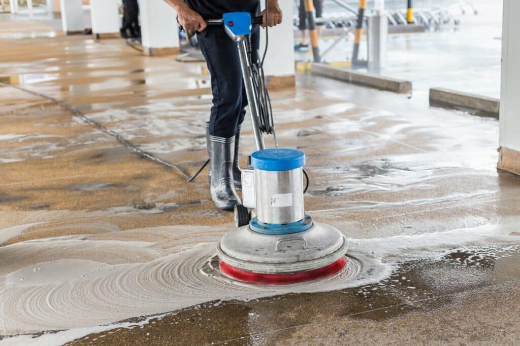 Worker cleaning and polishing walkway